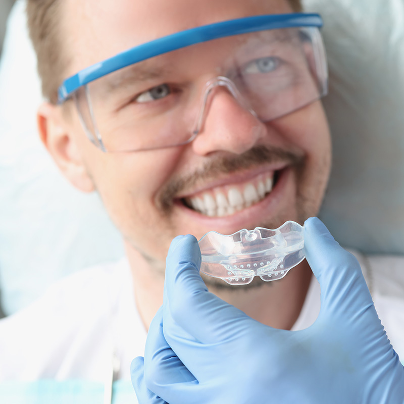 Dentist tries on transparent mouthguard to correct bite and bruxism problems