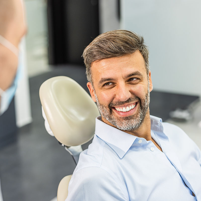 Handsome caucasian man sitting in armchair at office of dentist