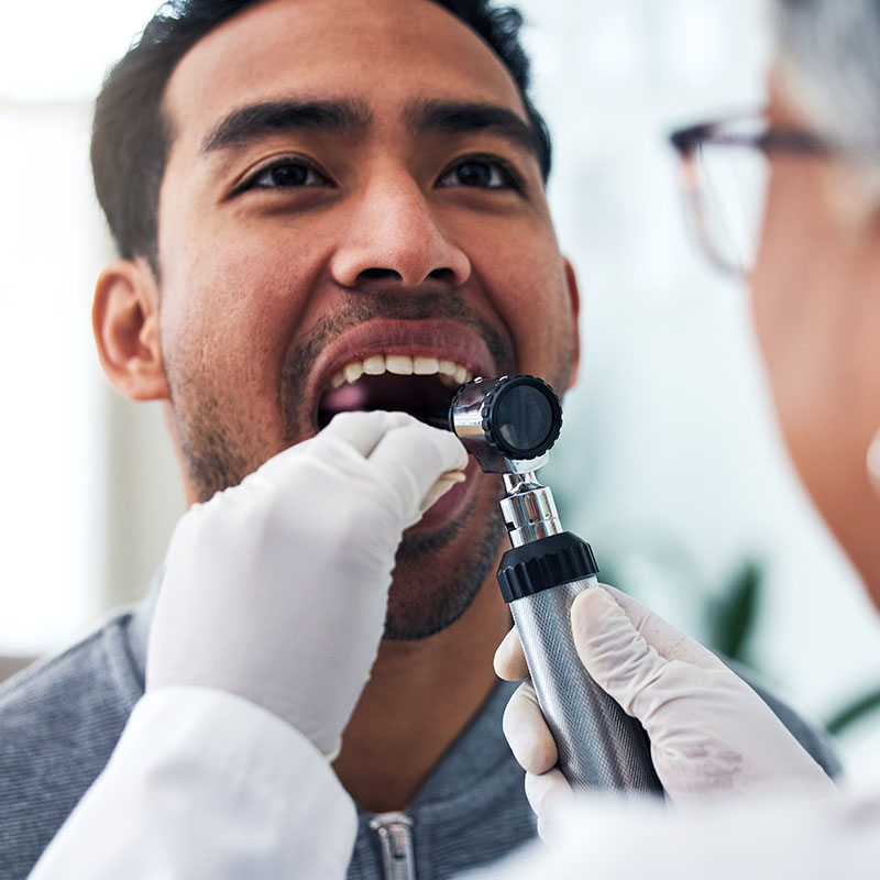 Doctor checking patient's throat in hospital for cancer