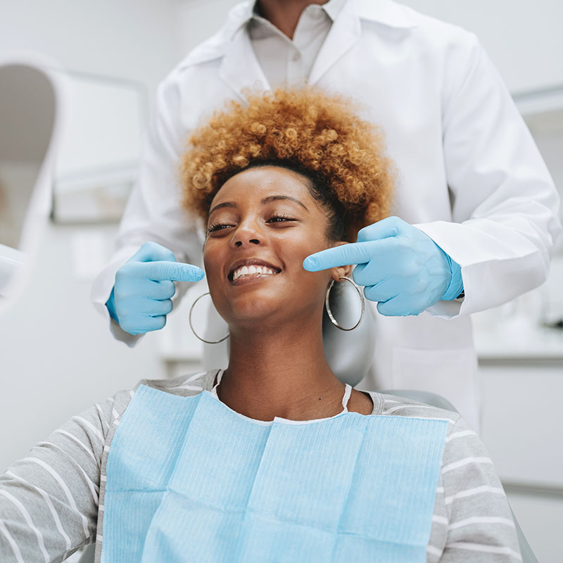 Woman in dentist office holding mirror